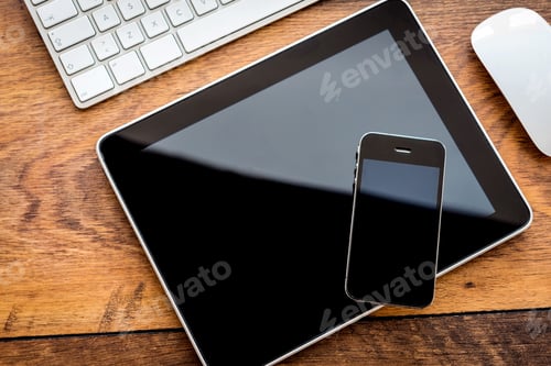Preview: Full interaction. Top view of digital tablet and mobile phone laying on wooden table