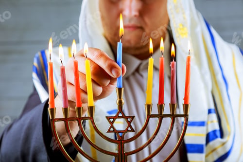 Preview: man hand lighting candles in menorah table served for Hanukkah