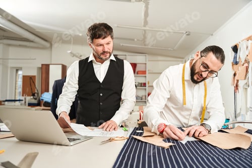 Preview: Clothier working in sewing workshop supervised by his colleague