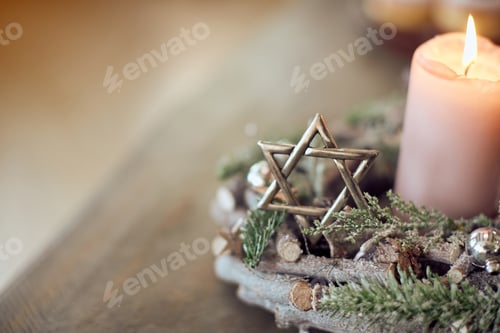 Preview: Close-up of star of David and candlelight on the table.