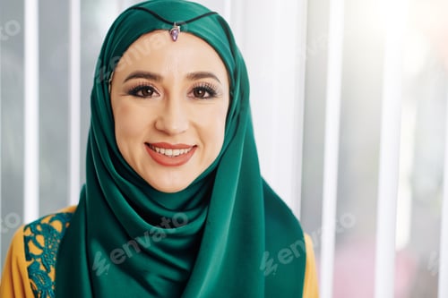 Preview: Smiling Woman in Green Hijab Posing Indoors