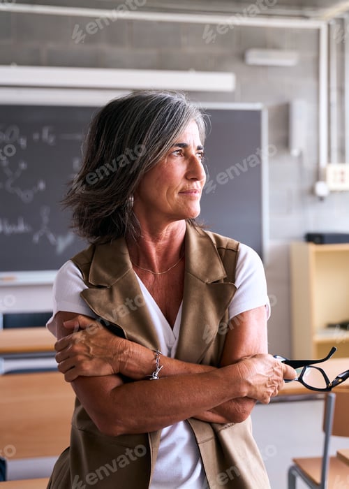 Preview: A teacher stands alone in an empty classroom, gazing thoughtfully out of the window