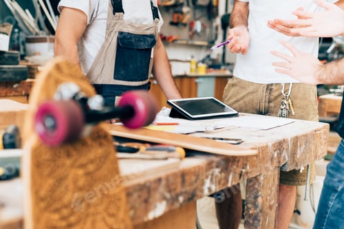 Preview: Young men working in skateboard workshop