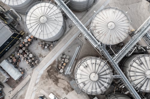 Preview: Aerial vie above Industrial storage or silo tanks in a row with connecting pipework
