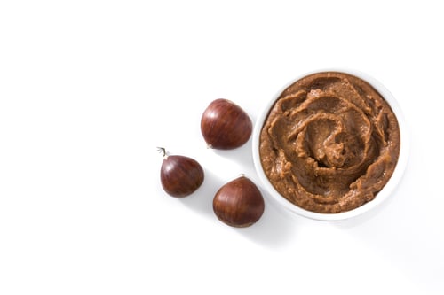 Preview: Chestnut cream in bowl with chestnuts on white background