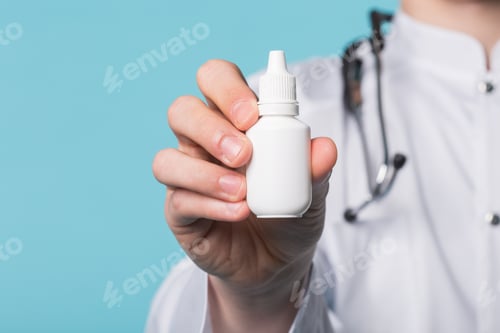 Preview: Medical drops in doctor's hand on blue background