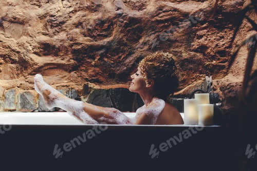 Preview: One woman enjoying bubble sopa bath leisure activity in the bathroom at home. Body skin care