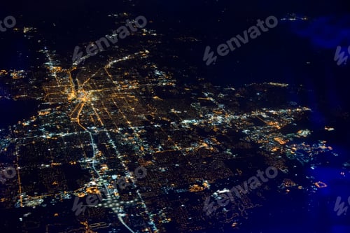 Preview: Aerial night view flying over a city lit up at night.