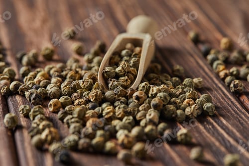Preview: Green peppercorns with wooden spatula scattered on wooden vintage background
