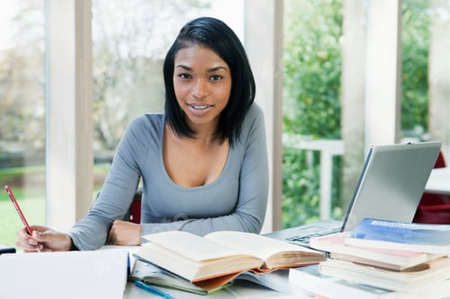 Preview: University student writing at desk, portrait