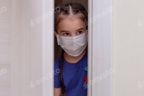 Preview: Little girl in blue clothes and white medical mask peers through the doorway