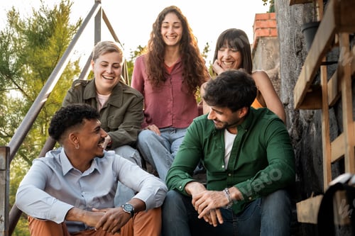 Preview: Diverse friends enjoying conversation and laughing on outdoor steps