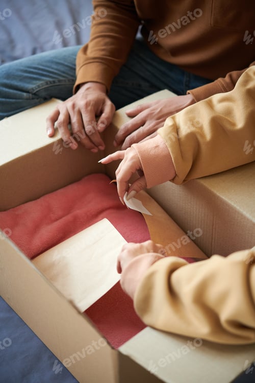 Preview: Couple unpacking the parcel with new clothes