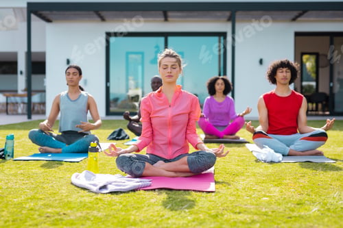 Preview: Diverse friends practicing yoga and meditating in garden