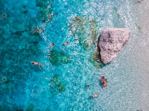 Preview: Swimmers embracing the azure waters of Sardinia in Baunei, Italy during a sunlit holiday