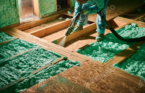 Preview: Worker spraying polyurethane foam for insulating wooden frame house.
