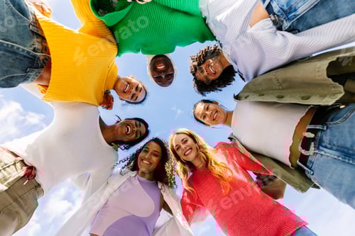 Preview: Low angle view of diverse group of young women hugging each other outdoors