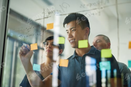 Preview: Planning is the first step. Cropped shot of a group of young designers planning on a glass board.