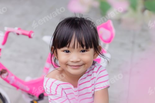 Preview: Face of smile and laugh Asian girl in head shot. Happy kid playing at the park playground.