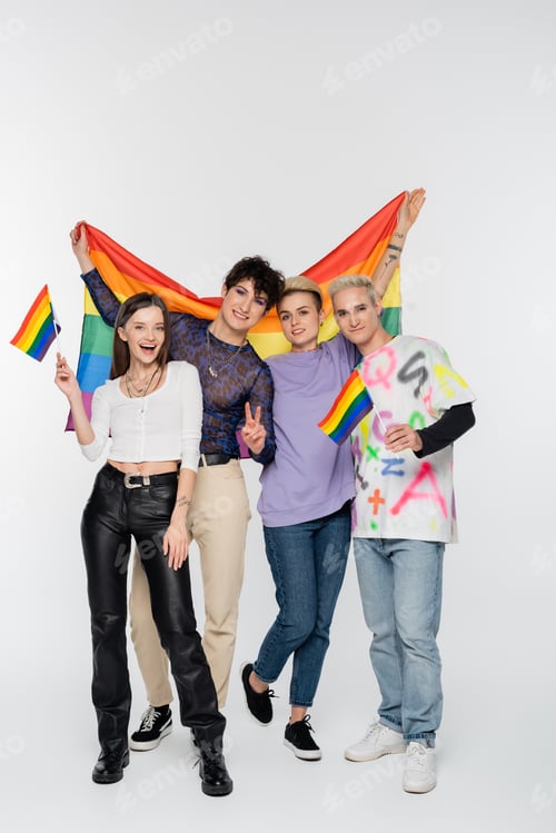 Preview: cheerful friends of diverse identity standing with lgbtq flags on grey background