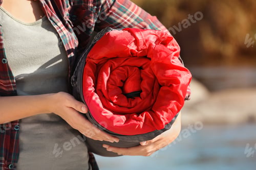 Preview: Female camper with sleeping bag outdoors, closeup