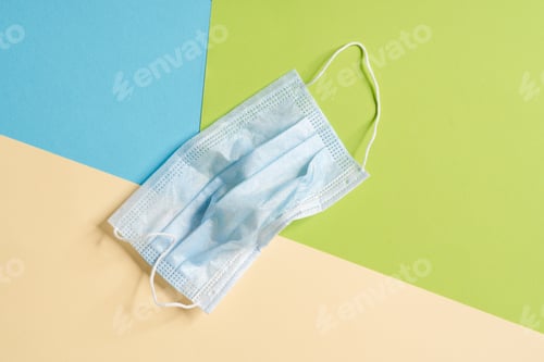 Preview: A crumpled protective mask lying on the colorful background in the studio