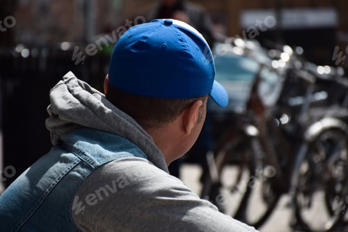 Preview: Portrait of middle aged man sitting on a curb looking away