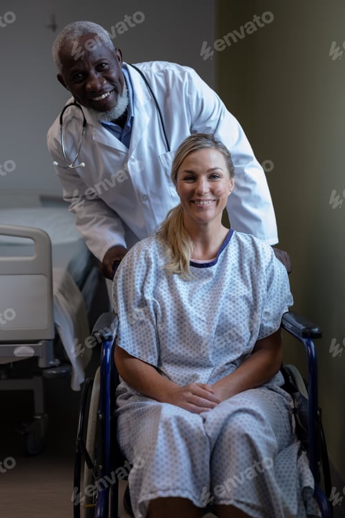 Preview: Portrait of diverse male doctor and female patient sitting on wheelchair smiling to camera