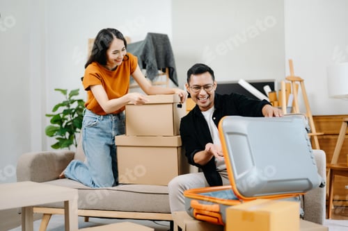Preview: Happy asian young attractive couple man and woman with big boxes moving into a new house,