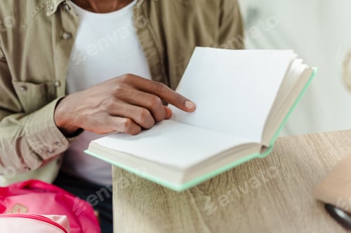 Preview: Cropped shot of a man pointing his finger at an open book page.