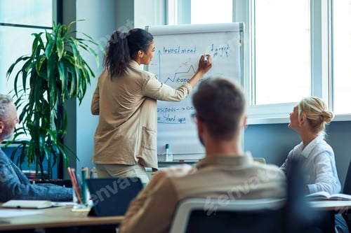 Preview: Discussing business strategy. Young mixed race business woman drawing a graph on flipchart, giving