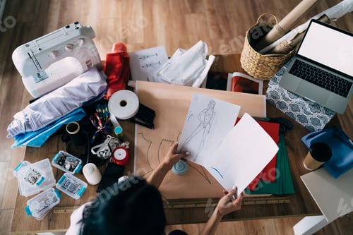 Preview: Crop seamstress working with paper drafts