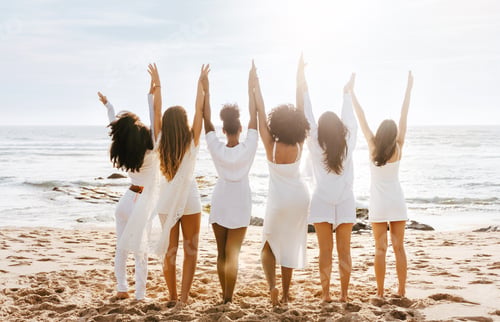 Preview: Hen party on the beach. Back view of group of diverse ladies walking by the seashore, holding and