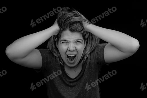 Preview: A frustrated and angry woman is screaming out loud and pulling her hair.For more images with realist