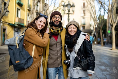 Preview: Portrait of three happy tourists standing on the street and looking at camera. Group of travelers