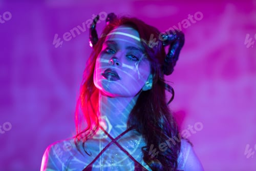 Preview: Woman makeup zodiac signs of Aries sign horoscope. Girl with horns on head in neon light.