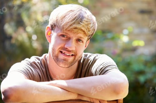Preview: Portrait Of Smiling Man At Home In Garden Against Flaring Sun
