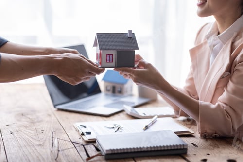 Preview: Young happy Asian woman receiving keys of their new home from real estate agent.concerning mortgage