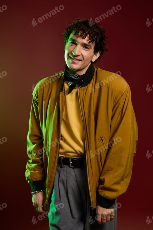 Preview: Stylish man radiating charisma with a vibrant backdrop and fashionable outfit