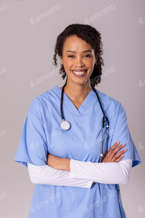 Preview: Portrait of smiling african american mid adult female doctor with arms crossed over white background
