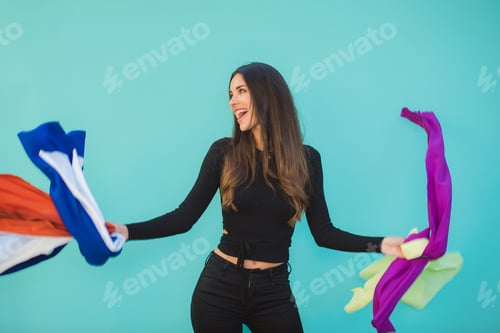 Preview: Happy shopper with assorted flying textiles on aquamarine background