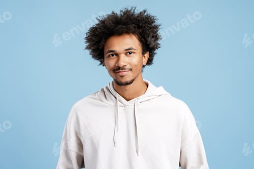 Preview: Portrait of handsome, African American man wearing stylish hoodie posing isolated on blue background