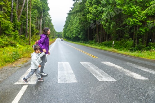 Preview: Mother and child crossing rainforest road in ucluelet, vancouver island
