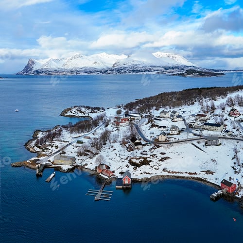 Preview: an island and small town surrounded by snow covered mountains and blue water