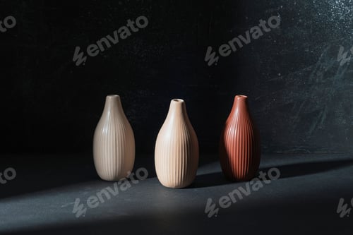 Preview: Three ceramic vases on black background in the light
