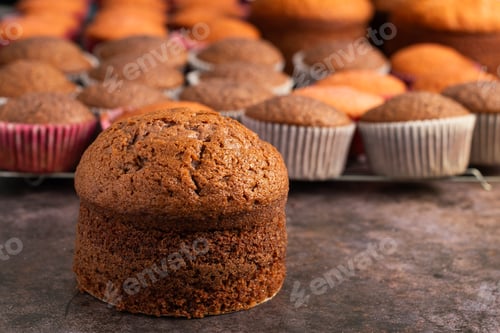 Preview: Small freshly baked cake and cupcakes in the background. Pastry table.