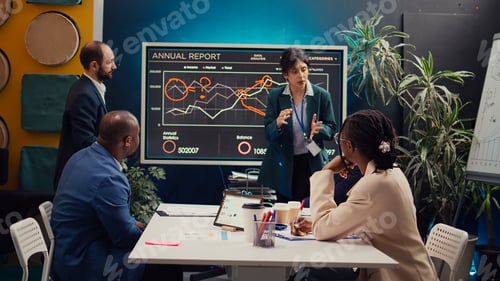 Preview: Skilled project team reviewing annual reports market trends in briefing meeting