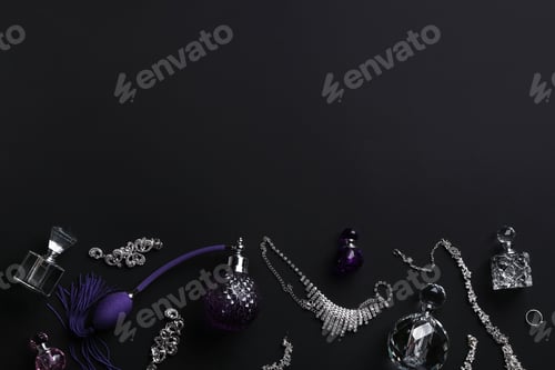 Preview: Composition with perfume bottles and jewellery on black background, flat lay. Space for text