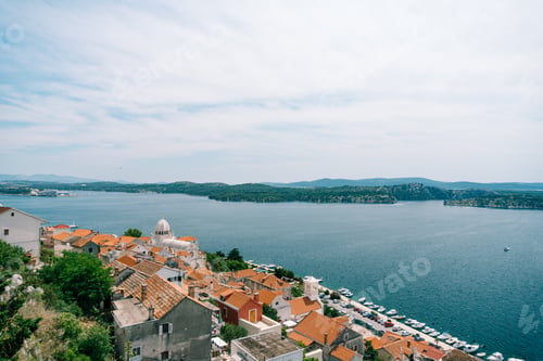 Preview: Beautiful view of the sea and the pier with yachts from behind the roofs of old houses in Sibenik