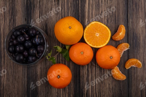 Preview: top view oranges with peeled wedges and cherry plum in a jar on wooden background